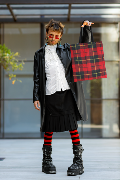 non binary person holding a tartan plaid tote bag