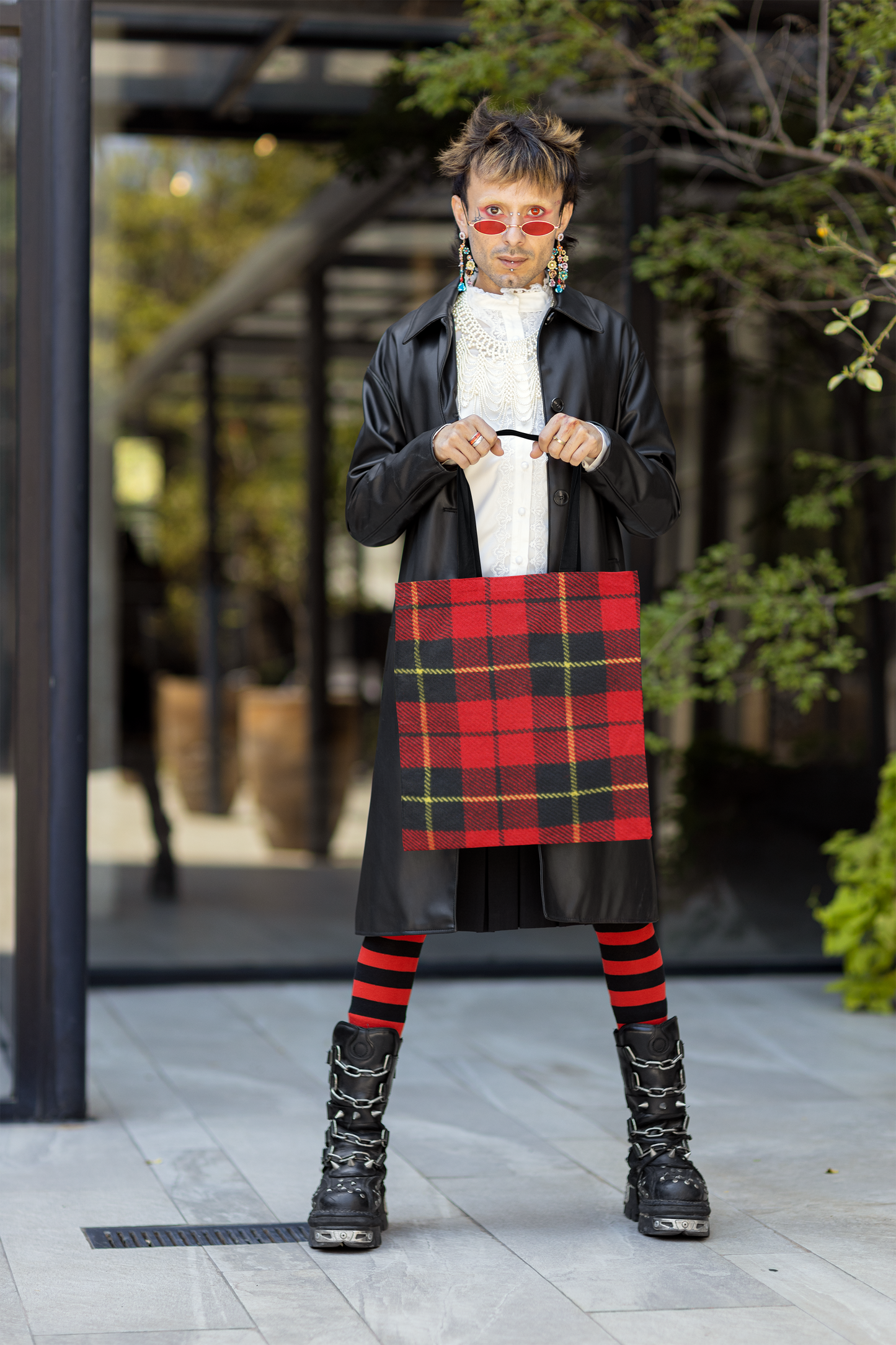 non binary person holding a tartan plaid tote bag