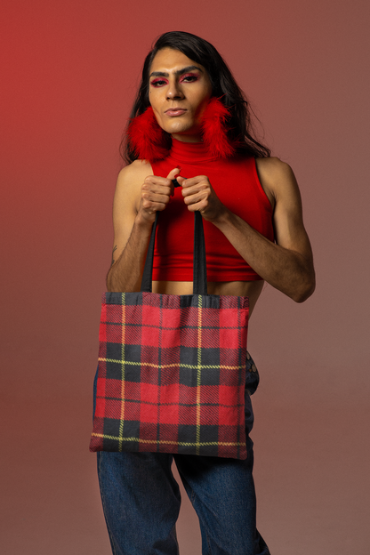 non binary person holding a tartan plaid tote bag