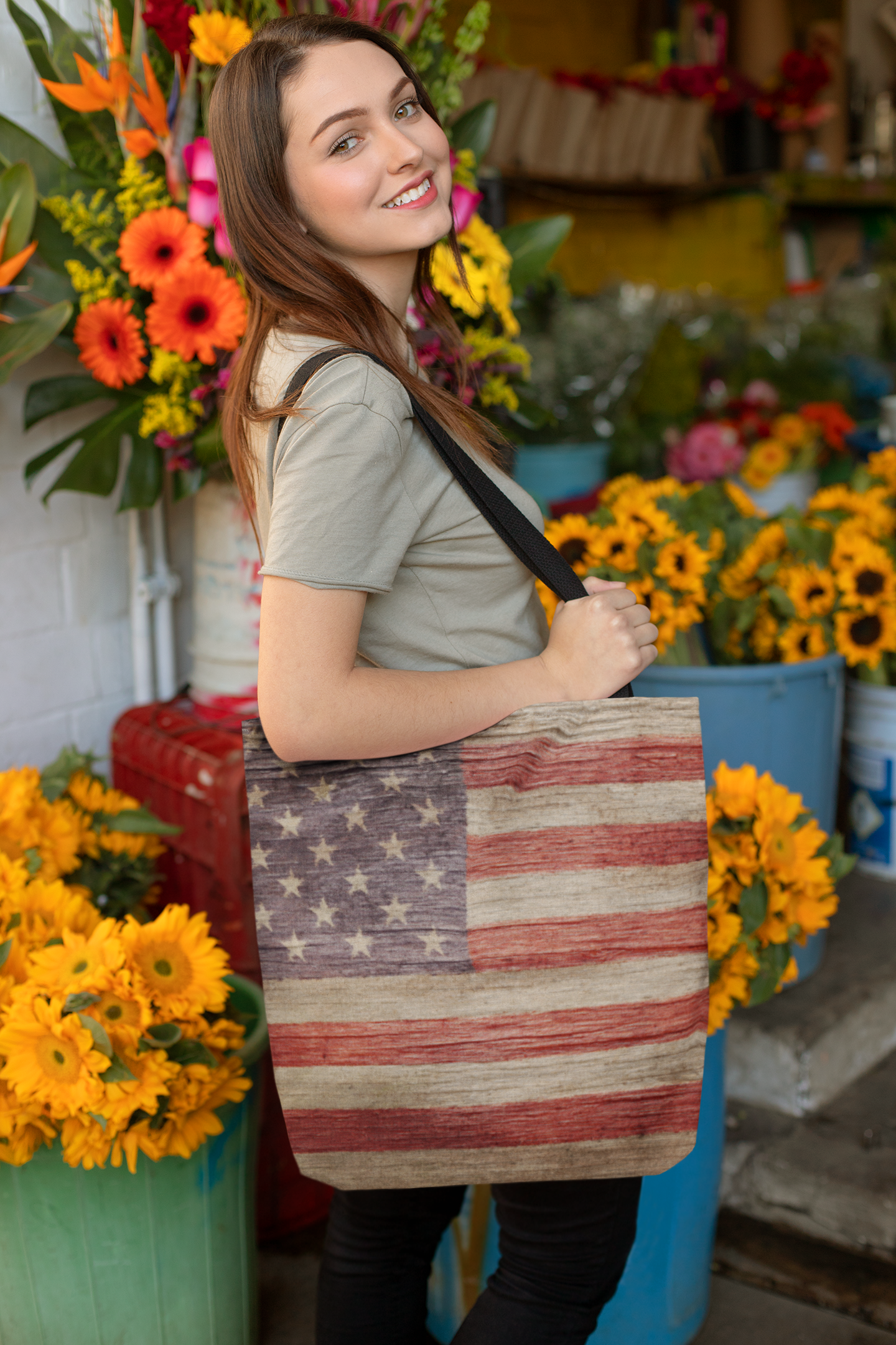 woman with an American flag tote bag at a market with lots of sunflowers