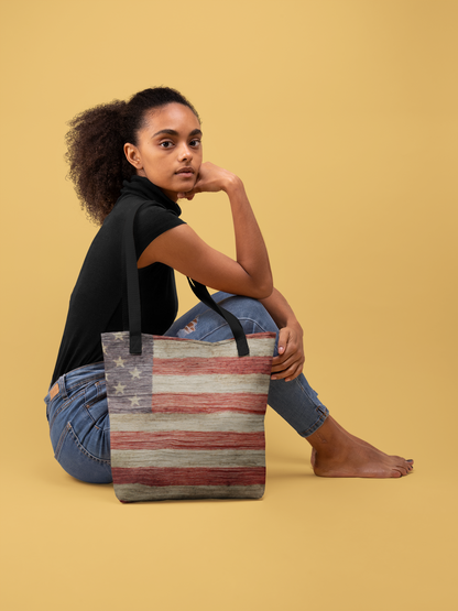 woman sitting on the floor with an American flag tote bag at her side